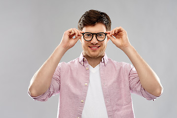 Image showing smiling young man in glasses over grey background