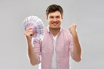 Image showing happy young man with fan of euro money