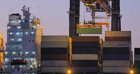 Image showing Loading containers on a ship at dawn