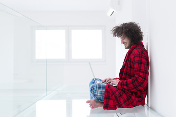Image showing young freelancer in bathrobe working from home