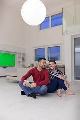 Image showing Young Couple using digital tablet on the floor