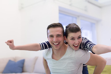 Image showing handsome man piggybacking his girlfriend