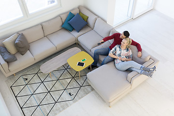 Image showing Young couple on the sofa watching television