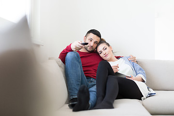 Image showing Young couple on the sofa watching television