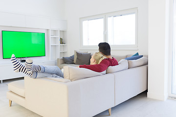 Image showing Young couple on the sofa watching television