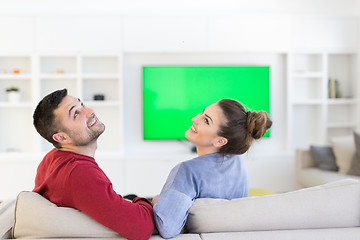 Image showing Young couple on the sofa watching television