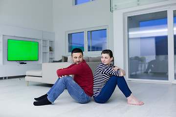 Image showing young couple sitting with back to each other on floor