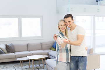 Image showing couple showing small red house in hands
