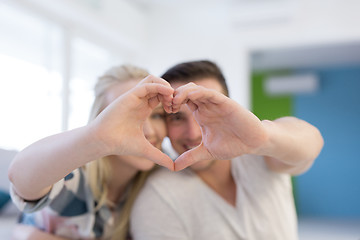 Image showing couple making heart with hands