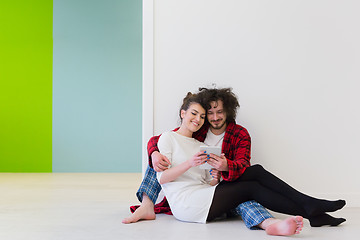 Image showing Young Couple using digital tablet on the floor