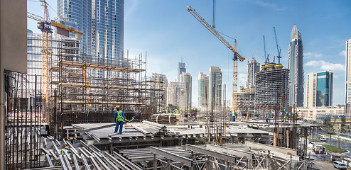 Image showing Laborers working on modern constraction site works in Dubai. Fast urban development consept