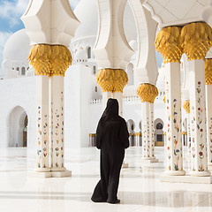 Image showing Traditionally dressed arabic woman wearing black burka wisiting Sheikh Zayed Grand Mosque in Abu Dhabi, United Arab Emirates