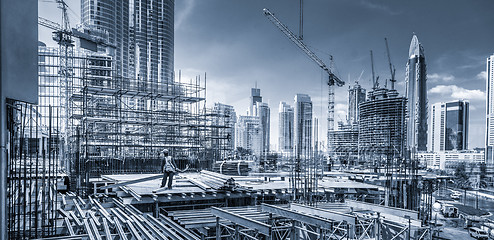 Image showing Laborers working on modern constraction site works in Dubai. Fast urban development consept