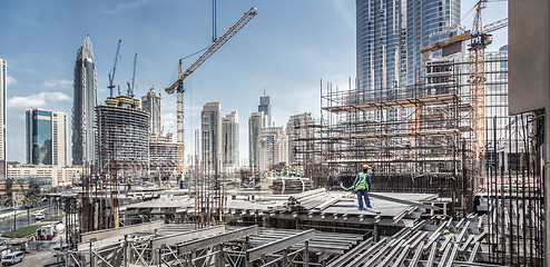 Image showing Laborers working on modern constraction site works in Dubai. Fast urban development consept