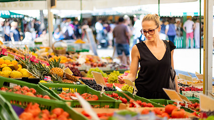 Image showing Woman buying fruits and vegetables at local food market. Market stall with variety of organic vegetable