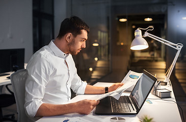 Image showing businessman with laptop working at night office