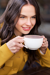 Image showing teenage girl drinking hot chocolate at city cafe