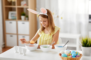 Image showing girl coloring easter eggs by liquid dye at home