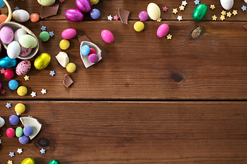 Image showing chocolate eggs and candy drops on wooden table