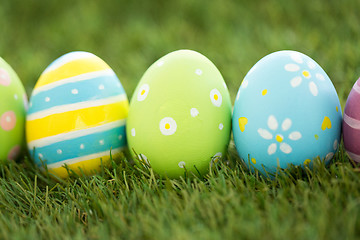 Image showing row of colored easter eggs on artificial grass