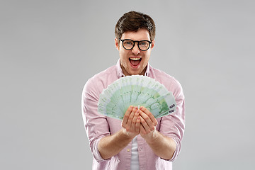 Image showing happy young man in glasses with fan of euro money