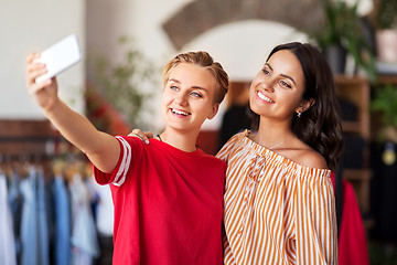 Image showing female friends taking selfie at clothing store