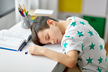 Image showing tired student boy sleeping on table at home