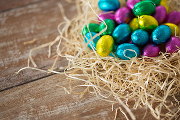 Image showing chocolate eggs in foil wrappers in straw nest