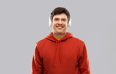 Image showing happy young man in headphones and red hoodie