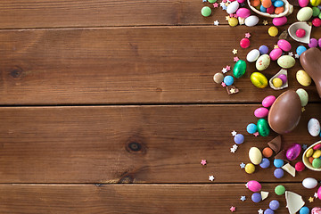 Image showing chocolate eggs and candy drops on wooden table