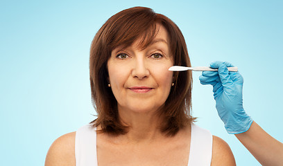 Image showing senior woman and surgeon hands with scalpel