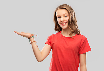 Image showing smiling teenage girl holding empty hand