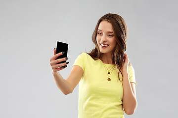 Image showing smiling teenage girl taking selfie by smartphone