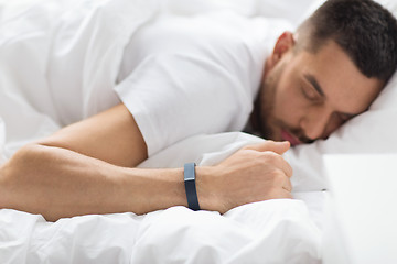 Image showing close up of man sleeping with activity tracker