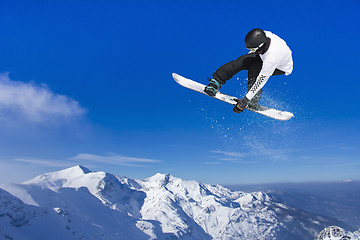 Image showing Skier Snowboarder jumping through air with sky in background