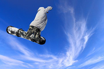 Image showing Skier Snowboarder jumping through air with sky in background