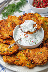 Image showing Zucchini fritters with yogurt sauce for breakfast.