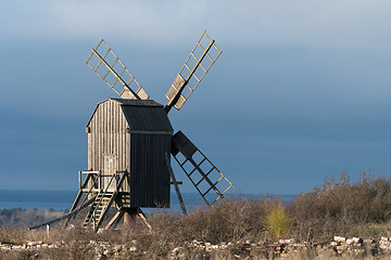 Image showing Sunlit grey old wooden windmill