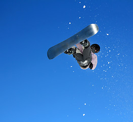 Image showing Snowboarder jumping through air with sky in background