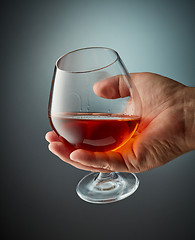 Image showing glass of cognac in human hand