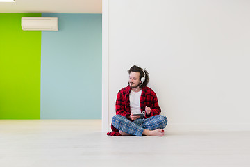 Image showing young man enjoying music through headphones