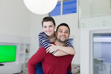 Image showing handsome man piggybacking his girlfriend