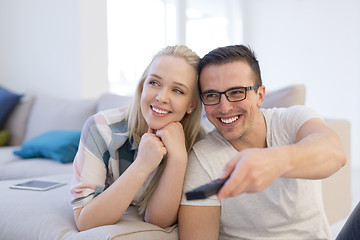 Image showing Young couple on the sofa watching television