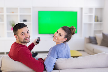 Image showing Young couple on the sofa watching television