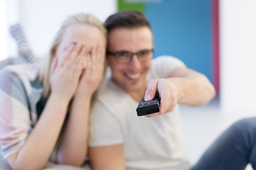 Image showing Young couple on the sofa watching television