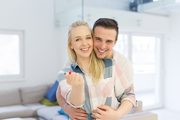 Image showing couple showing small red house in hands