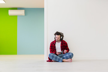 Image showing young man enjoying music through headphones