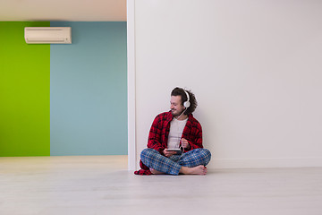 Image showing young man enjoying music through headphones