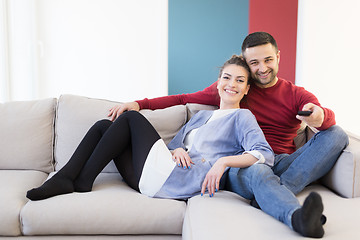 Image showing Young couple on the sofa watching television