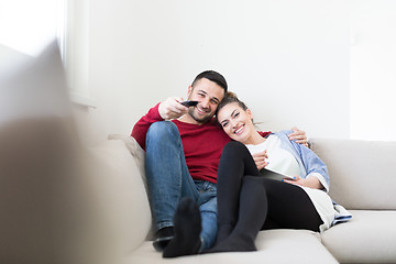 Image showing Young couple on the sofa watching television